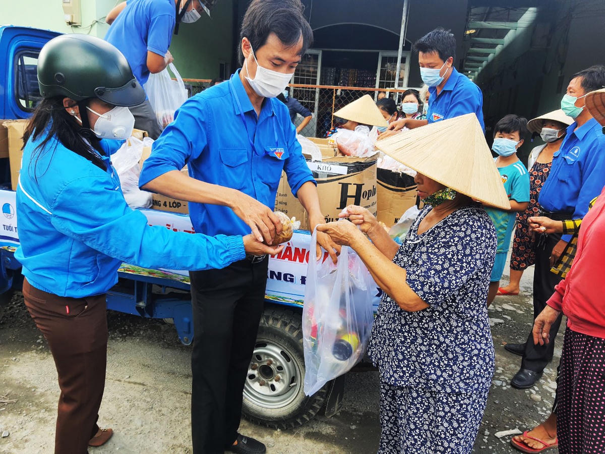 Lực lượng đoàn viên thanh niên hỗ trợ tích cực phát những phần quà đến tay người dân.