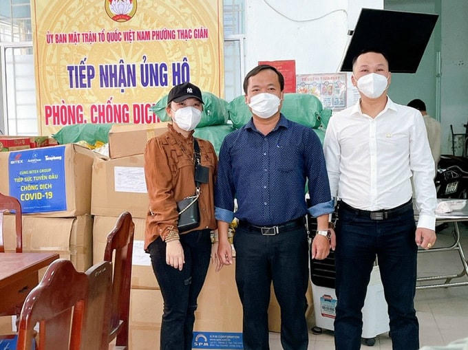 Chị Mai Thảo (áo nâu) mang nhu yếu phẩm được đổi bằng hoa lan đến ủng hộ ở phường Thạc Gián, trưa ngày 24/6. Ảnh: Mai Thảo.