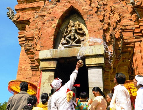 Nghi thức té nước thần Shiva trước cửa tháp Chăm.