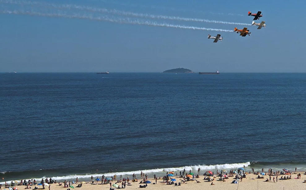 Máy bay trình diễn vẽ khói cho mọi người trên bãi biển Copacabana, Rio de Janeiro, Brazil. Bãi biển đêm giao thừa hàng năm của thành phố Rio de Janeiro và màn bắn pháo hoa công phu đã bị hủy do đại dịch Covid-19 hoành hành.