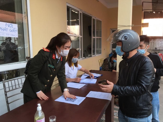 Người dân qua chốt kiểm soát cầu Nghìn tiến hành khai báo y tế theo hướng dẫn của cán bộ tại chốt.
