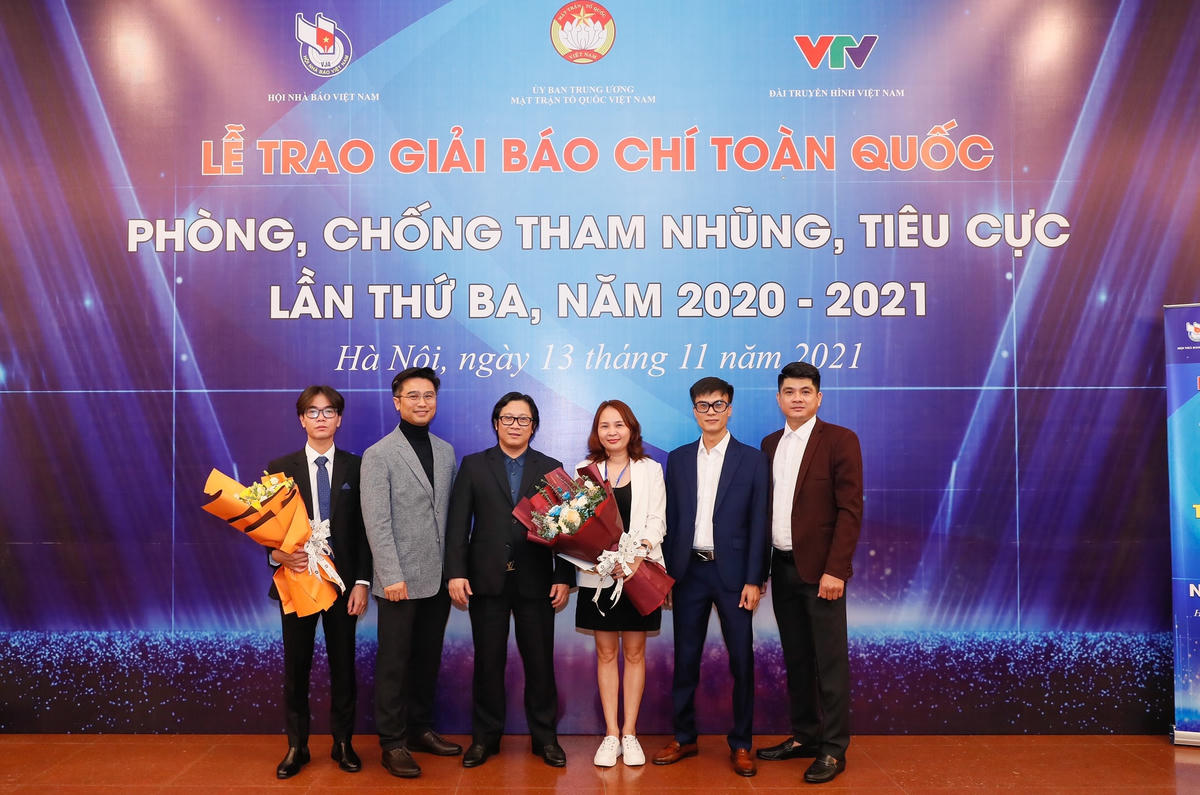Quyền Tổng Biên tập Báo Đại Đoàn Kết Lê Anh Đạt tặng hoa chúc mừng các tác giả đoạt giải.