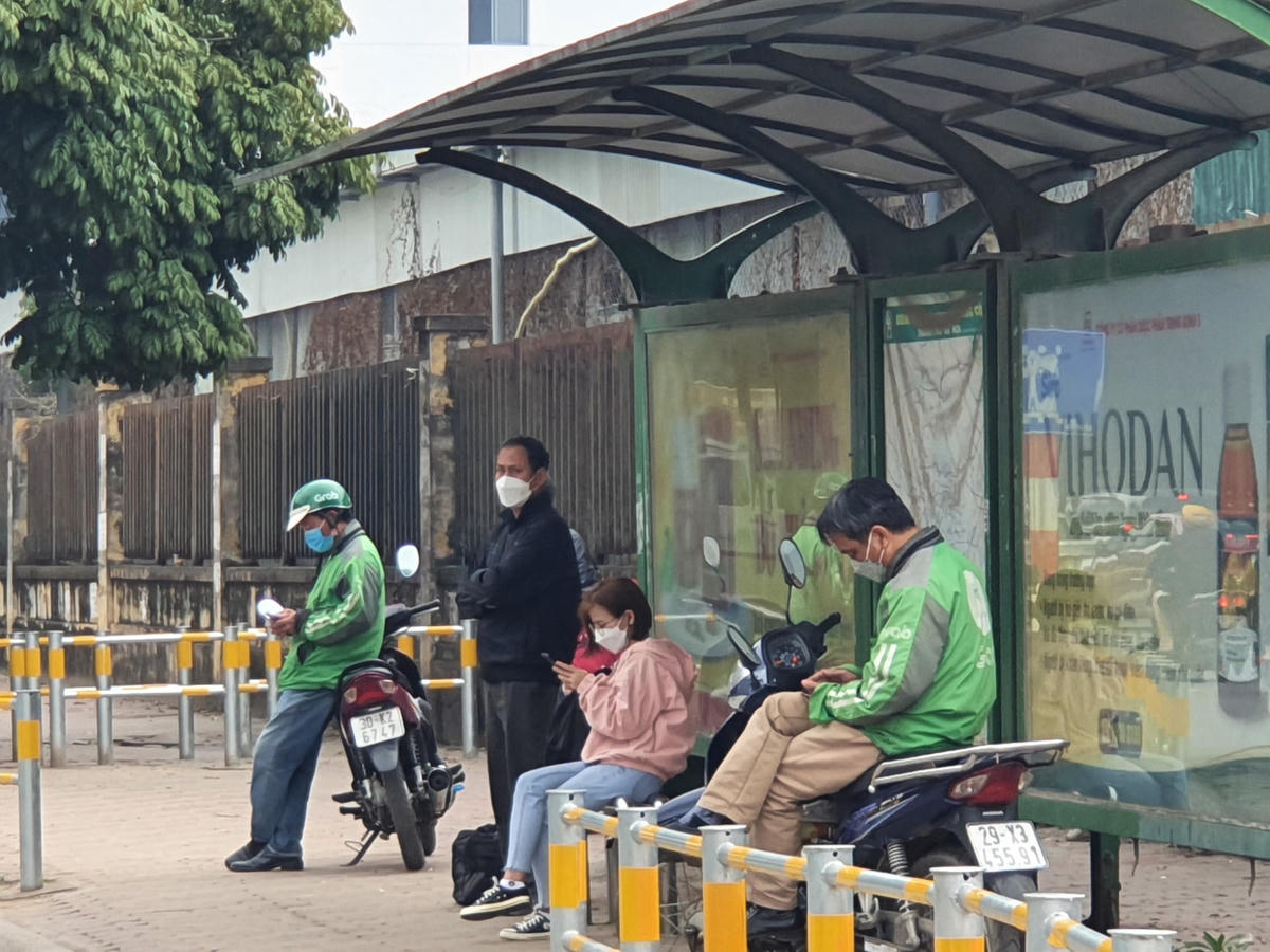 Ông Bình (áo xanh bên phải) luôn trực chờ quanh khu vực bến xe Mỹ Đình ngóng chờ từng vị khách.