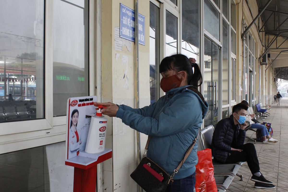 Khách sát khuẩn tay trước khi lên xe.