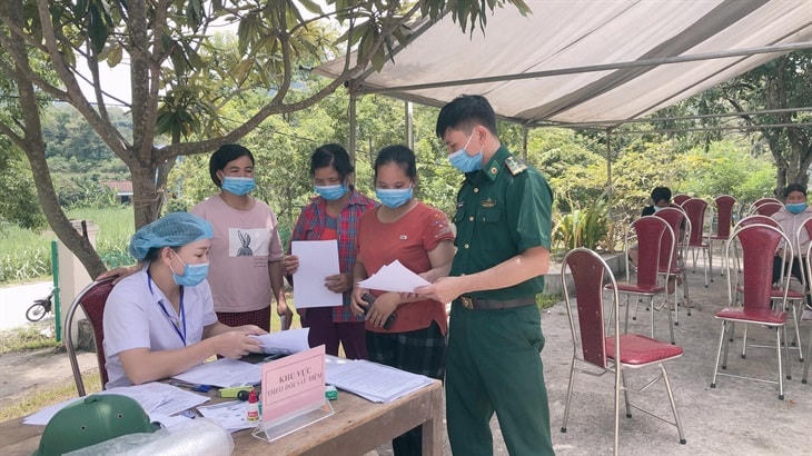 Cán bộ y tế hướng dẫn các thủ tục cho bà con dân tộc Tày, Nùng sinh sống tại khu vực biên giới của xã Thị Hoa, (huyện Hạ Lang, tỉnh Cao Bằng) khi tiêm vaccine. Ảnh: Đức Linh.