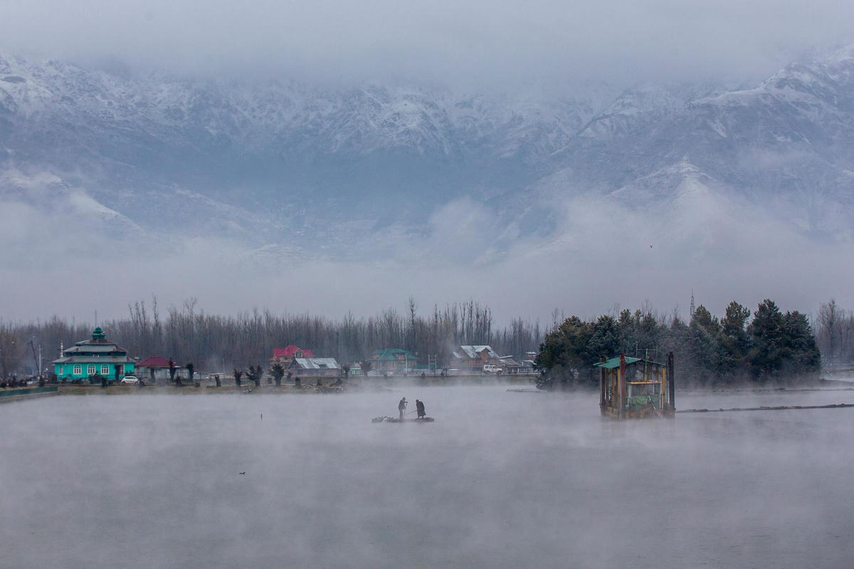 Trận tuyết rơi ngắn cũng đủ khiến hồ Dal ở ngoại ô Srinagar, Kashmir do Ấn Độ kiểm soát đóng băng trắng xóa, ngày 27/2/2021. Ảnh: AP.  