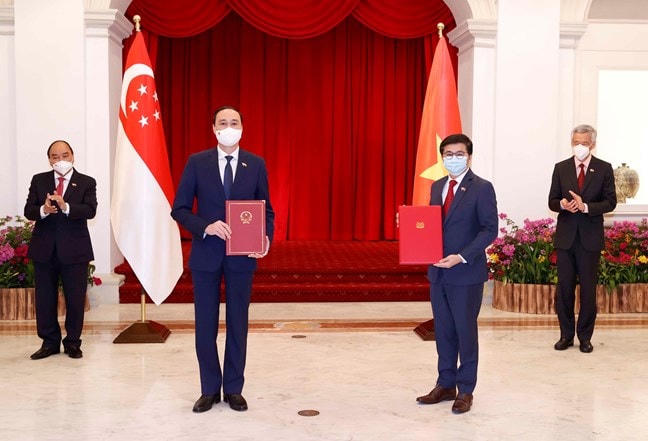 Chủ tịch nước Nguyễn Xuân Phúc với Thủ tướng Singapore Lý Hiển Long chứng kiến đại diện UBTƯ MTTQ Việt Nam và Hiệp hội Nhân dân Singapore trao đổi văn kiện hợp tác giai đoạn 2022-2024.
