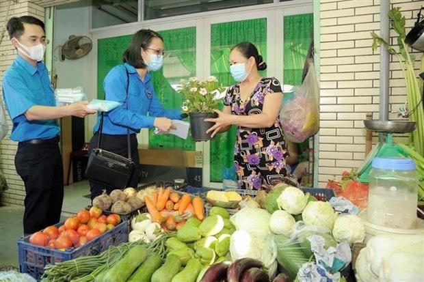 Đoàn viên thanh niên Thành phố Hồ Chí MInh tặng khẩu trang miễn phí cho tiểu thương chợ Lò Gốm (Quận 6). (Ảnh minh họa: Hồng Giang/TTXVN).