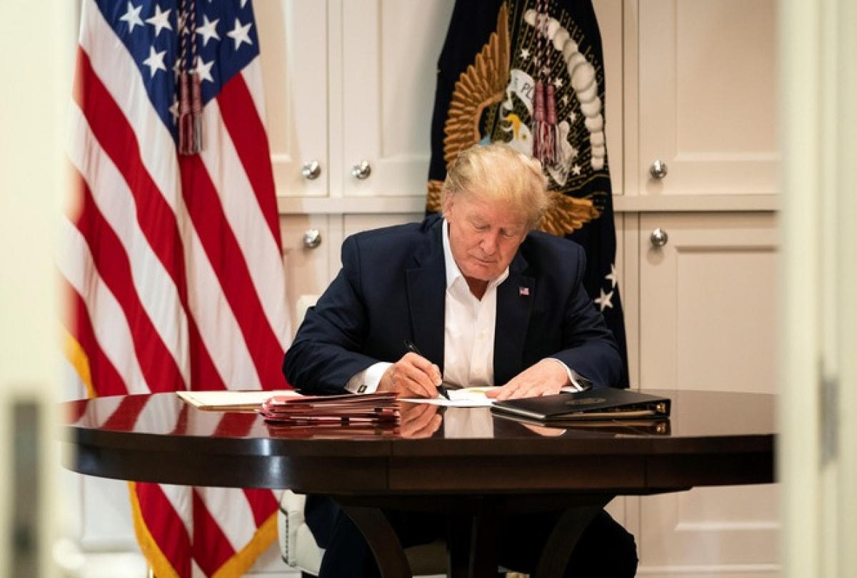 Ông Trump mặc vest ngồi làm việc trong khi đang điều trị Covid-19. Ảnh: CNN.