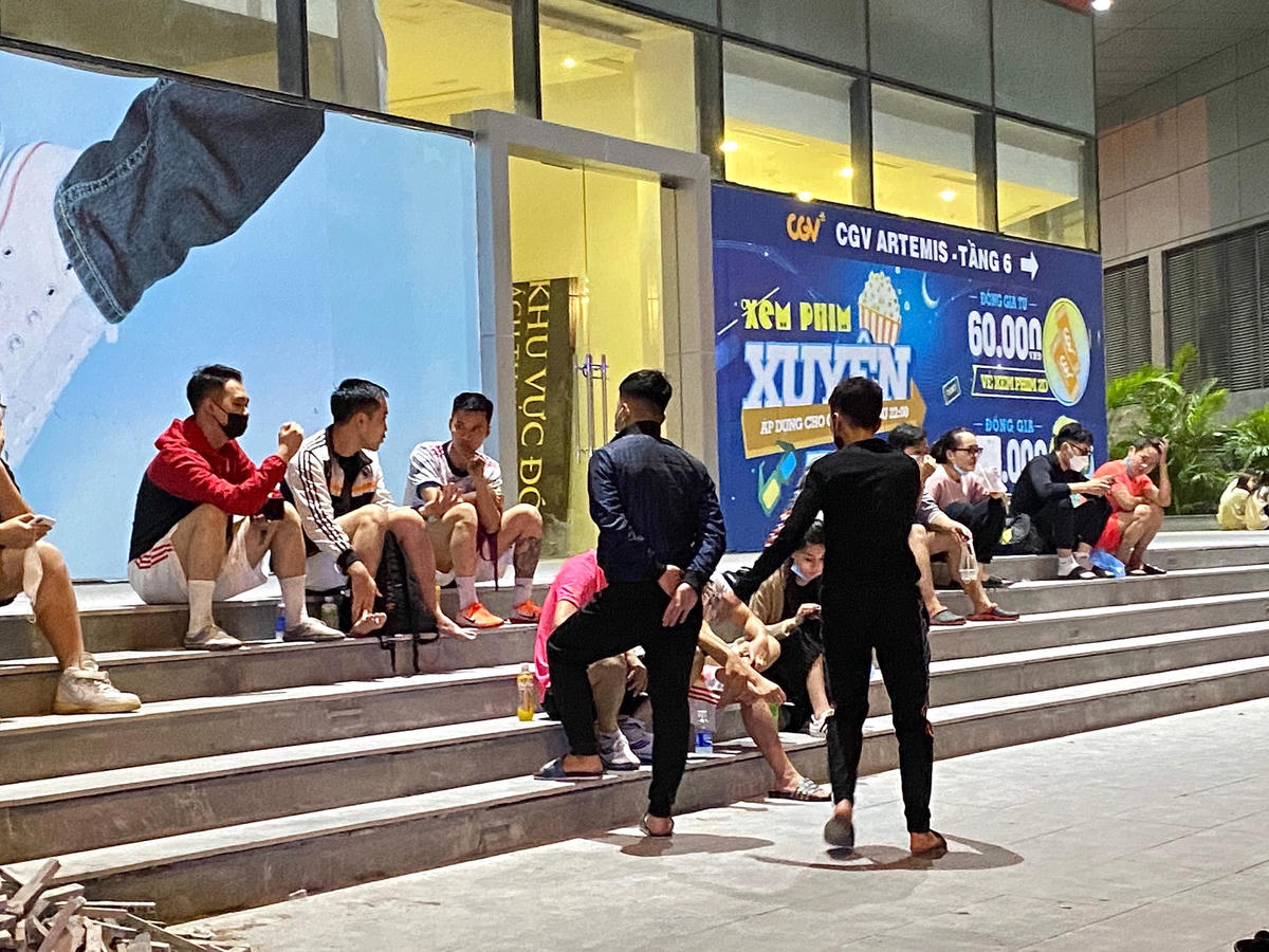 Một số cửa hàng tiện lợi tại Hà Nội không nhận khách ngồi lại sau 21h nhưng khách hàng vẫn tụ tập phía ngoài, vô tư trò chuyện không đeo khẩu trang.