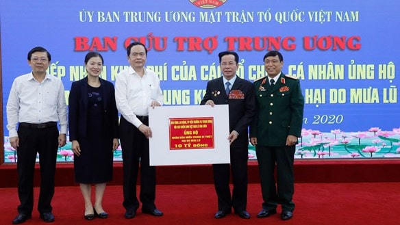Chủ tịch Trần Thanh Mẫn tiếp nhận ủng hộ từ Anh hùng Lao động Lê Văn Kiểm. Ảnh: Quang Vinh.