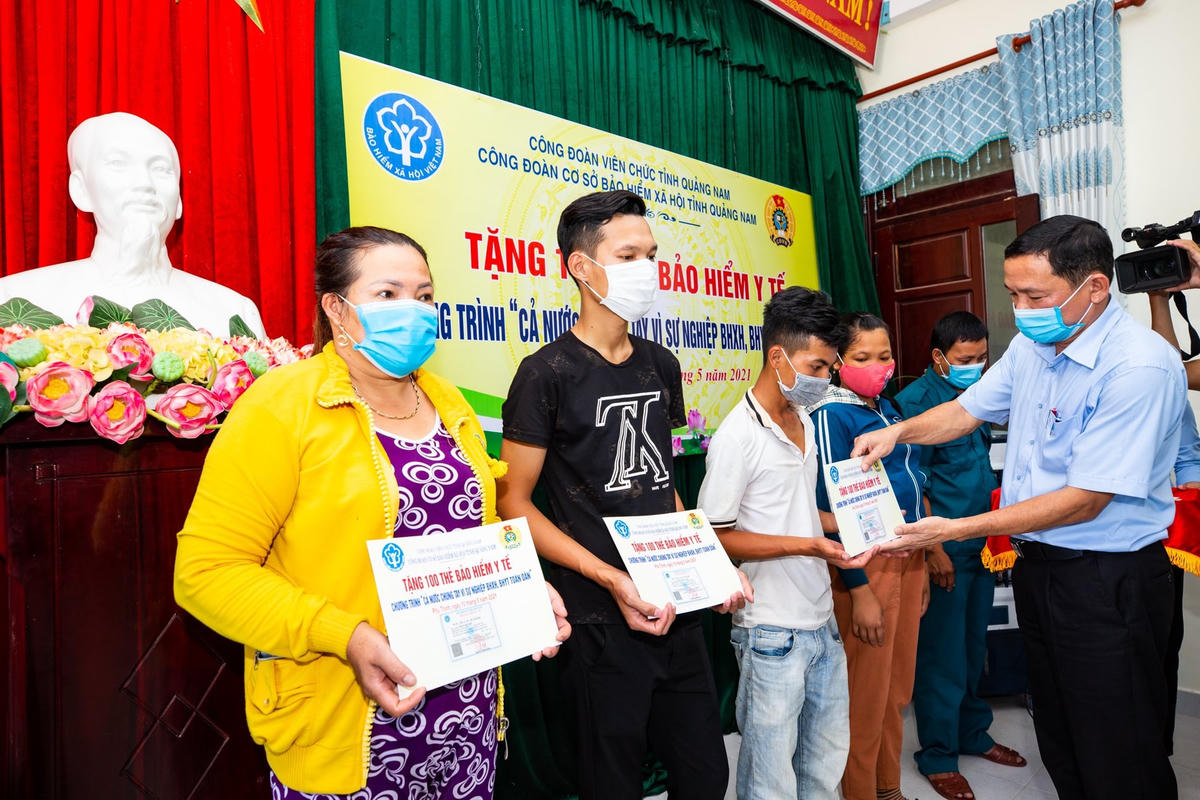 Giám đốc BHXH tỉnh Quảng Nam trao tặng thẻ BHYT cho người nghèo.
