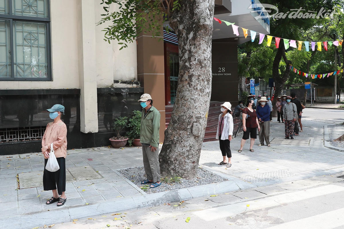 Mọi người xếp hàng để nhận suất ăn, đảm bảo đúng yêu cầu về phòng, chống dịch Covid-19. Ảnh: Quang Vinh.  