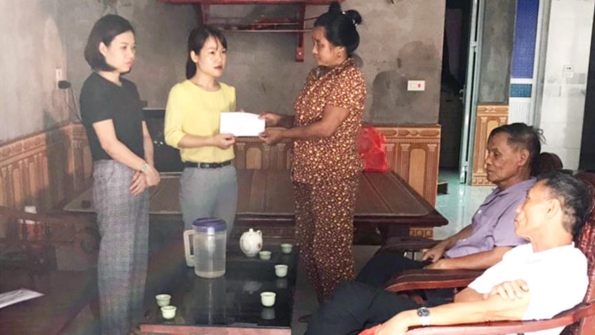 Chủ tịch Ủy ban MTTQ Việt Nam xã Hùng Lô Lã Thị Diệu Mai (ở giữa) thăm và tặng quà các hộ nghèo trên địa bàn xã.