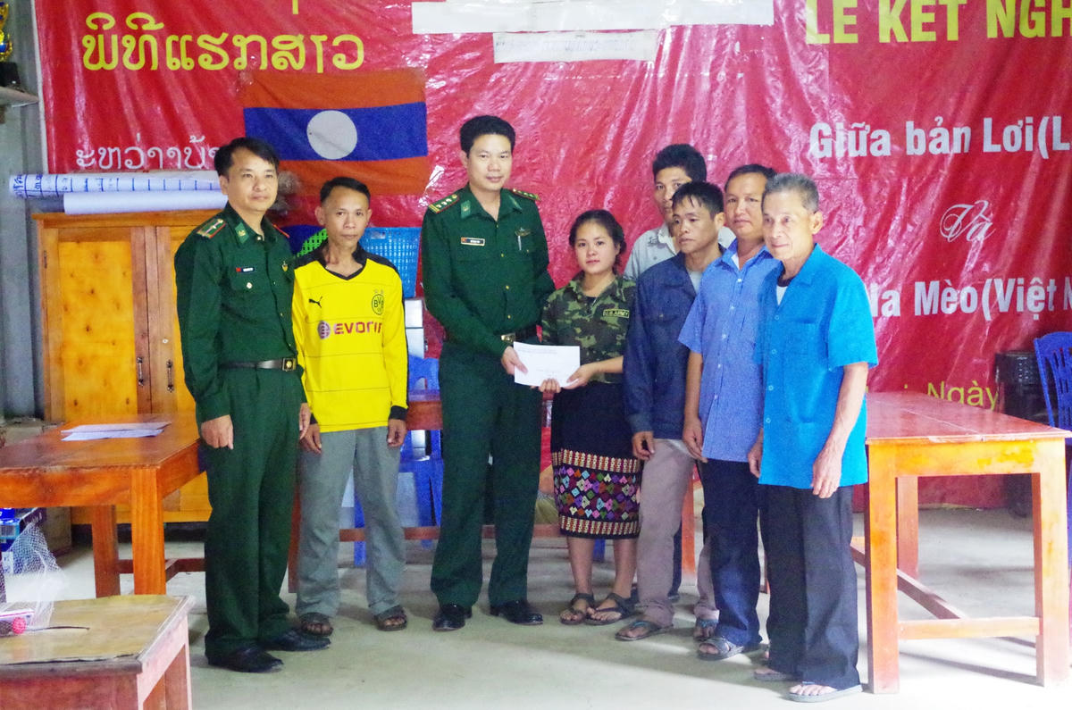 Thượng tá Hồ Ngọc Thu trao quà cho em học sinh bản Lơi, huyện Viêng Xay.