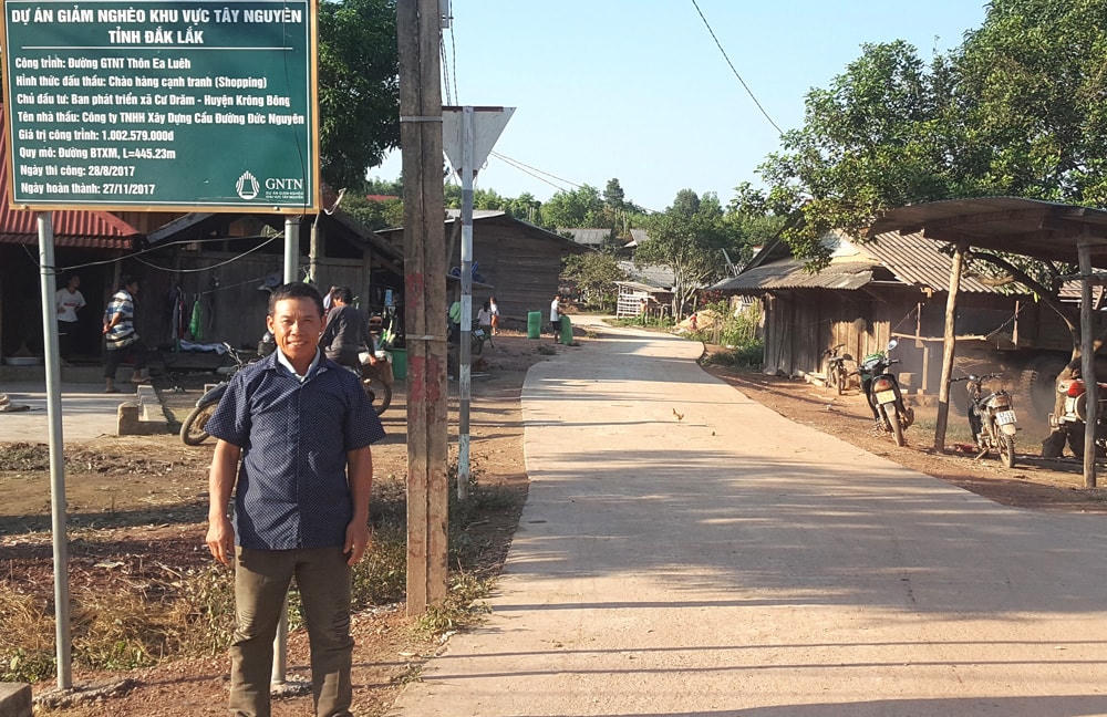 Ông Vàng Seo Cơ trên đoạn đường bê tông nội vùng mới hoàn thành do gia đình hiến một phần đất.