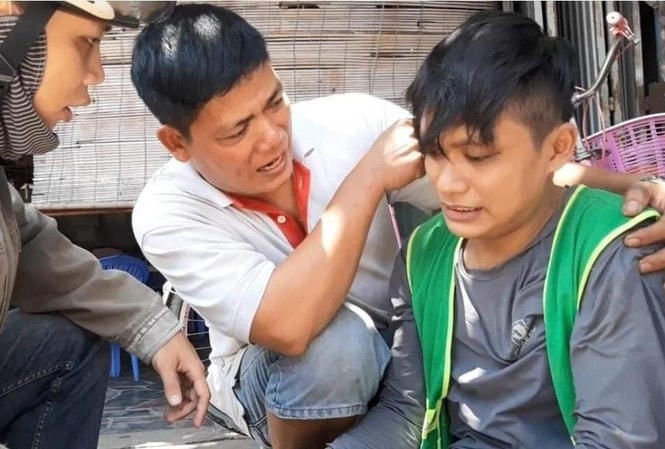 Anh Lê Anh Hựu (ở giữa) hỗ trợ một thanh niên bị tai nạn trên đường. Ảnh: NVCC.