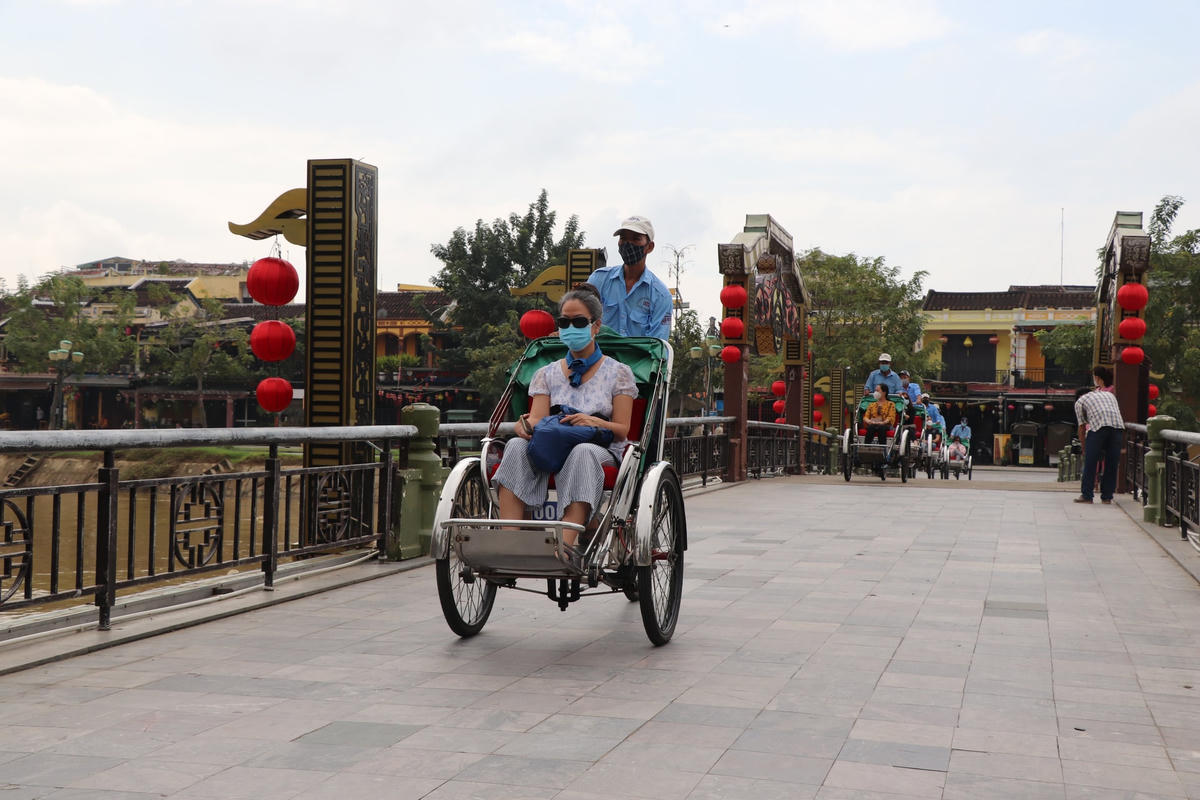 Một du khách tham quan phố cổ Hội An bằng xích lô.