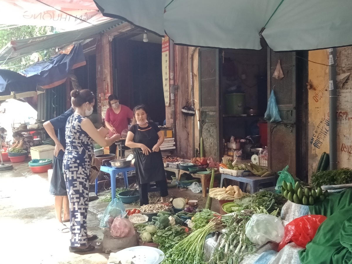 Người dân tại chợ tạm ngõ 104 Nguyễn An Ninh vô tư mua hàng, trong khi người bán không đeo khẩu trang.