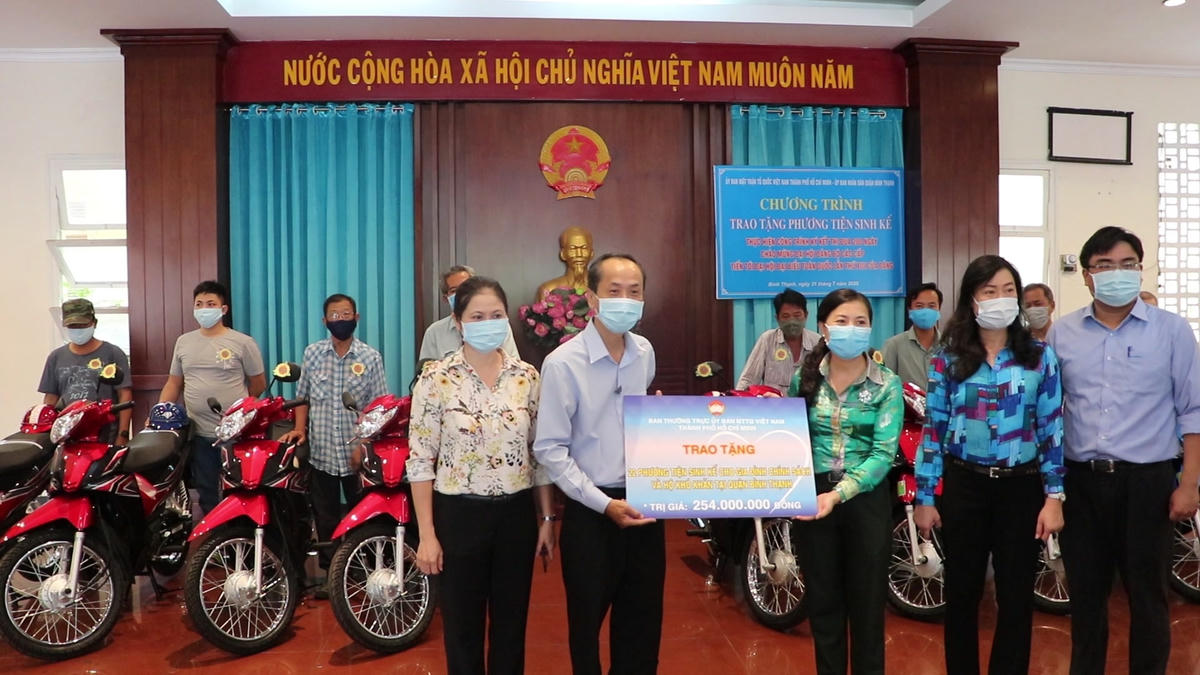 Bà Phan Kiều Thanh Hương, Phó Chủ tịch Ủy ban MTTQ Việt Nam TP HCM trao bảng tượng trưng cho đại diện UBND quận để hỗ trợ các gia đình nghèo.