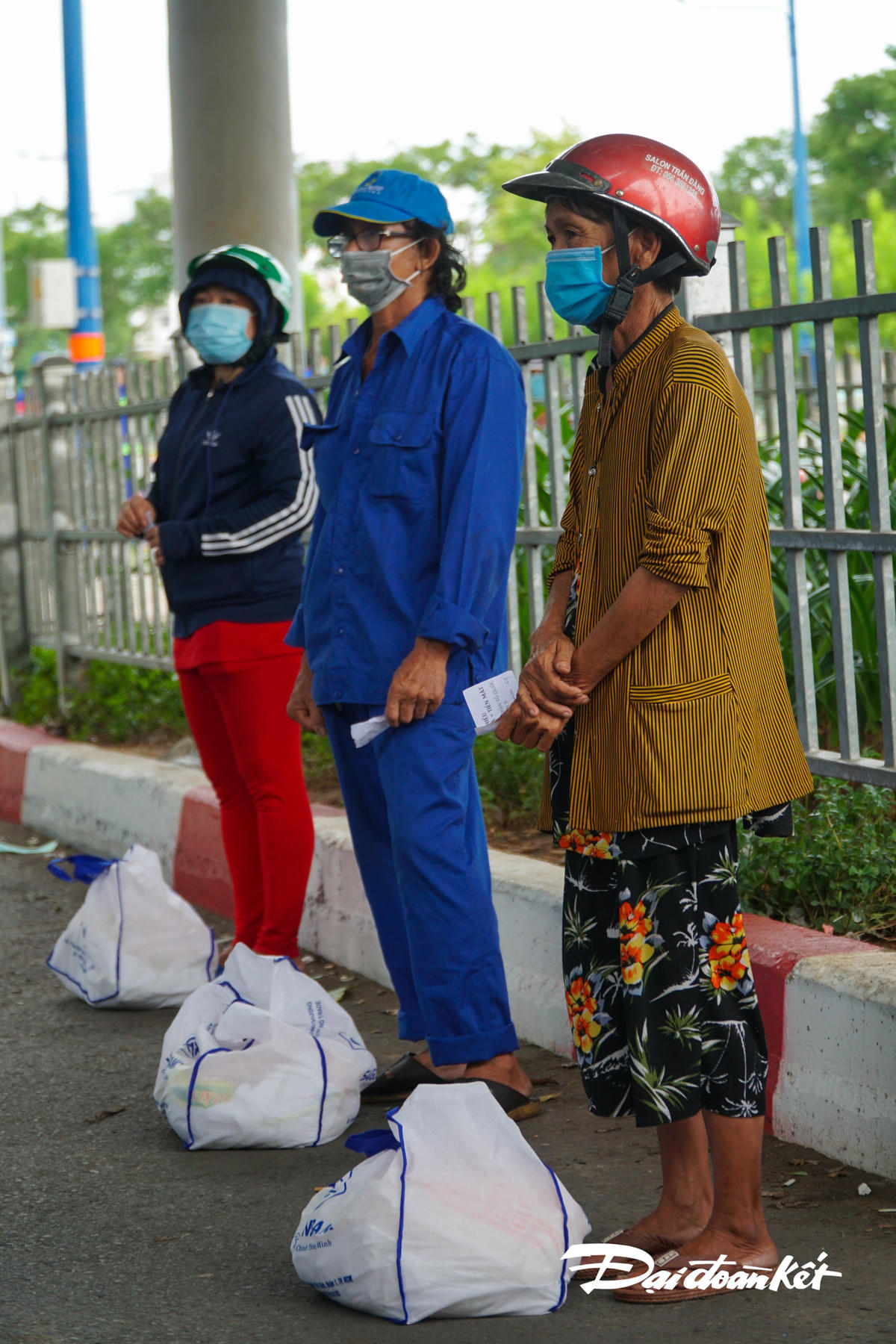 Công nhân trong HTX vệ sinh môi trường Quận 5 đứng giãn cách, nhận quà từ phia MTTQ Quận 5.