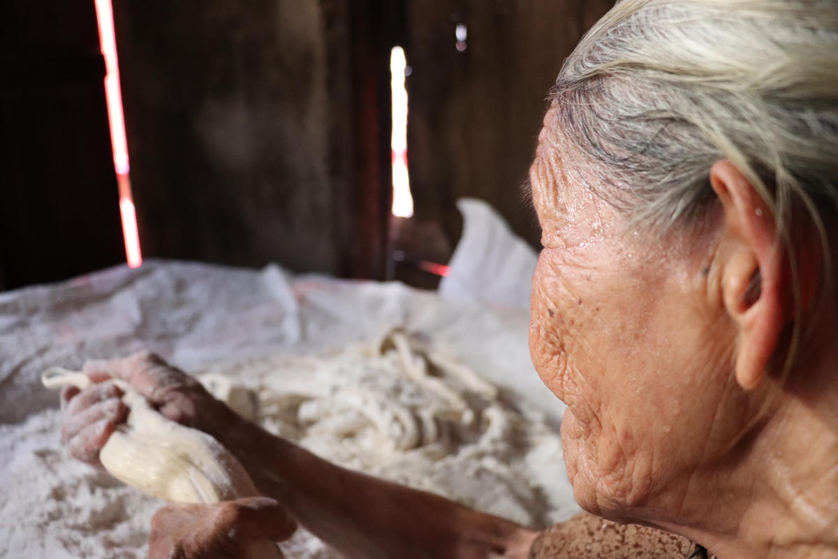 Những giọt mồ hôi đã ướt đẫm trên má cụ Năm trong khi làm.