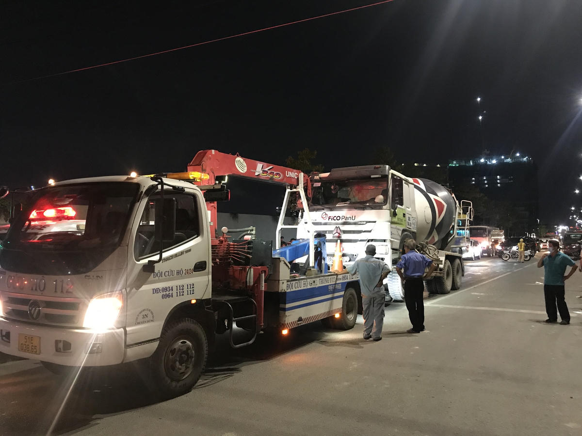 Xe cẩu đang nâng xe bồn trộn bê tông để đưa thi thể nạn nhân ra ngoài. Ảnh: TL