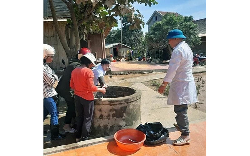 Cán bộ Trung tâm Y tế huyện Minh Hóa (Quảng Bình) hướng dẫn người dân xử lý nguồn nước sạch sau ngập lụt Ảnh: Hương GIang.