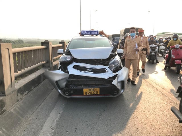 Chiếc xe taxi bị vỡ nát phần đầu.