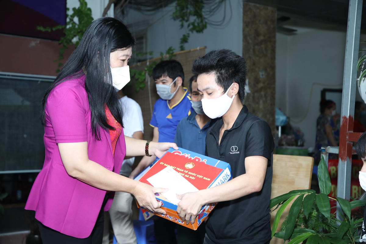 Chủ tịch Ủy ban MTTQ Việt Nam TP Hà Nội Nguyễn Lan Hương trao quà cho những người lao động nghèo và sinh viên gặp khó khăn do ảnh hưởng dịch bệnh.