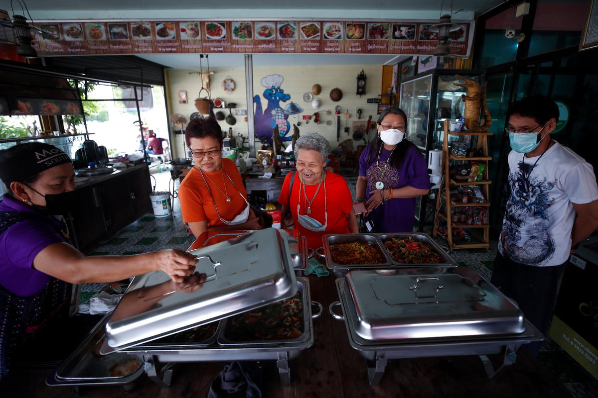Khách hàng đang đứng xem các món ăn làm từ thịt cá sấu tại nhà hàng ở Nakhon Pathom. Ảnh: Diego Azubel / EPA.