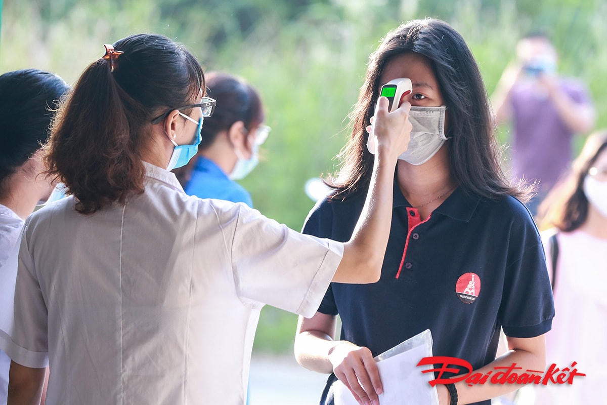 Thí sinh được đo thân nhiệt trước khi vào cổng trường.