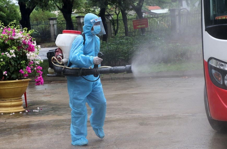Nhân viên y tế khử trùng các phương tiện ra vào khu vực bệnh viện dã chiến. (Ảnh: Quốc Dũng/TTXVN).  
