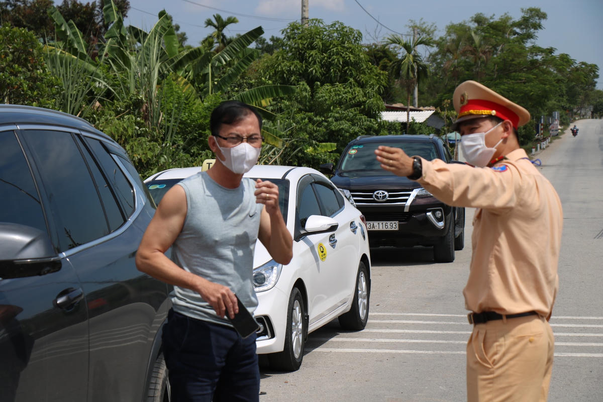 Cán bộ CSGT hướng dẫn tài xế vào chốt kiểm soát để khai báo y tế.