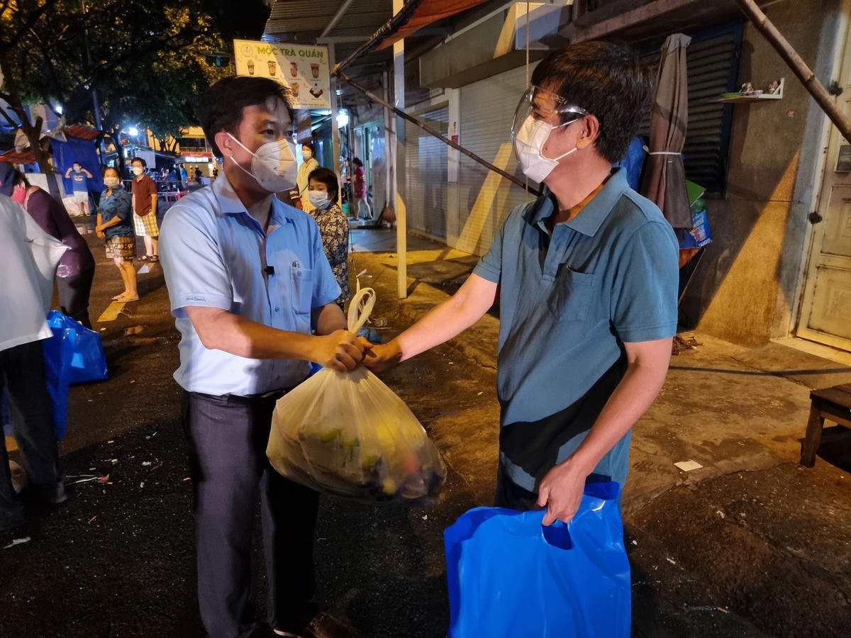 Ông Lê Tấn Tài – Chủ tịch Ủy ban MTTQ Việt Nam Quận 5 (bìa trái) tròa quà cho người dân trong khu vực phong tỏa.