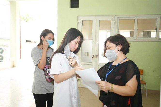 Thí sinh được yêu cầu cởi khẩu trang kiểm tra trước khi vào phòng thi.