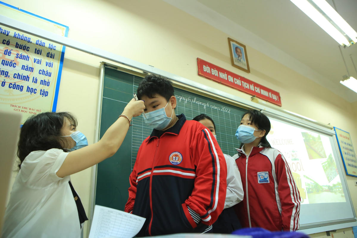 Học sinh tiến hành đo thân nhiệt trước khi vào lớp. 