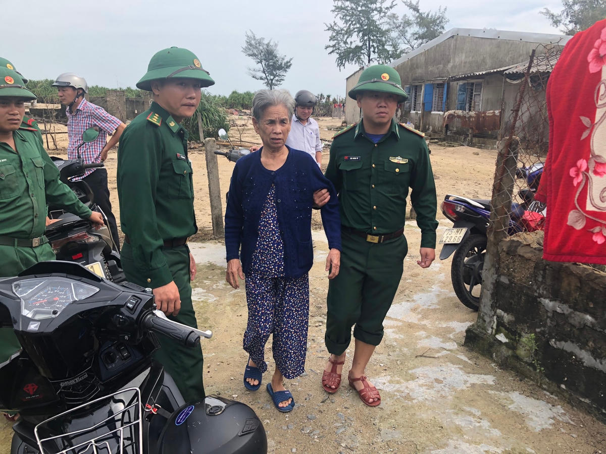 Một cụ già được lực lượng chức năng hỗ trợ đưa đến nơi tránh bão.