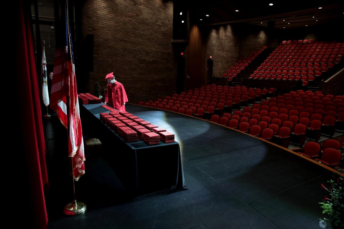 Một học sinh nhận bằng tốt nghiệp tại Trường Trung học Cộng đồng Bradley-Bourbonnais trong một khán phòng trống rỗng, không có bạn bè, gia đình hoặc người thân nào được tham dự do đại dịch Covid-19. Ảnh: Getty Images.  