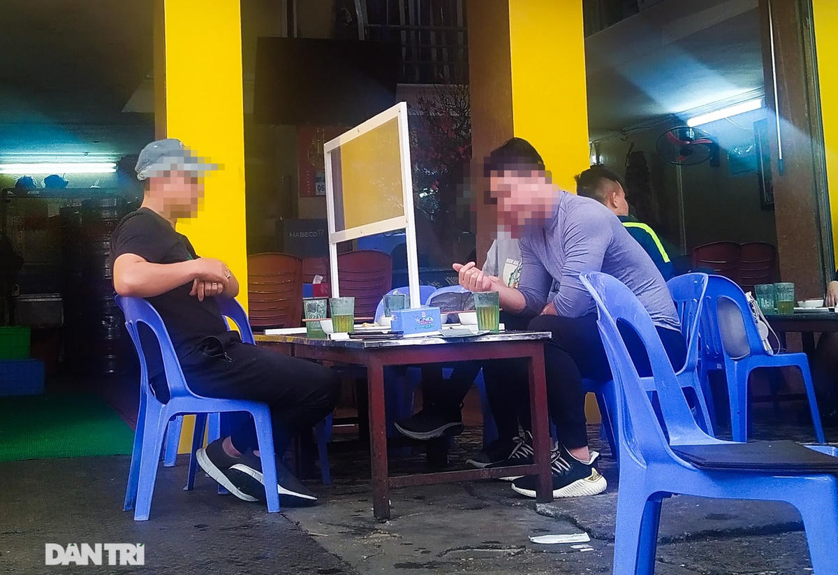 Hai thực khách ăn nhậu, nói chuyện rôm rả qua vách chắn trong suốt bằng kính.