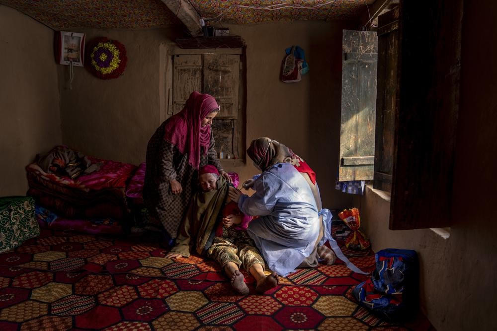 Một phụ nữ lớn tuổi người Kashmir đang tiêm vaccine Covishield trong một đợt tiêm chủng tại nhà ở quận Budgam, phía tây nam Srinagar, vùng núi Kashmir thuộc Ấn Độ. Ảnh AP / Dar Yasin.