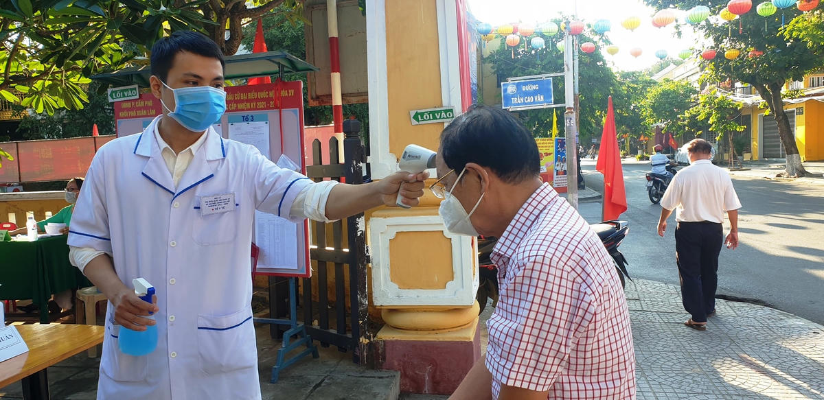 Các cử tri ở phường Cẩm Phô, TP Hội An được đo thân nhiệt.