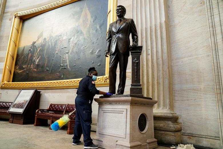 Một công nhân làm vệ sinh bức tượng cựu Tổng thống Ronald Reagan. Ảnh: Reuters.