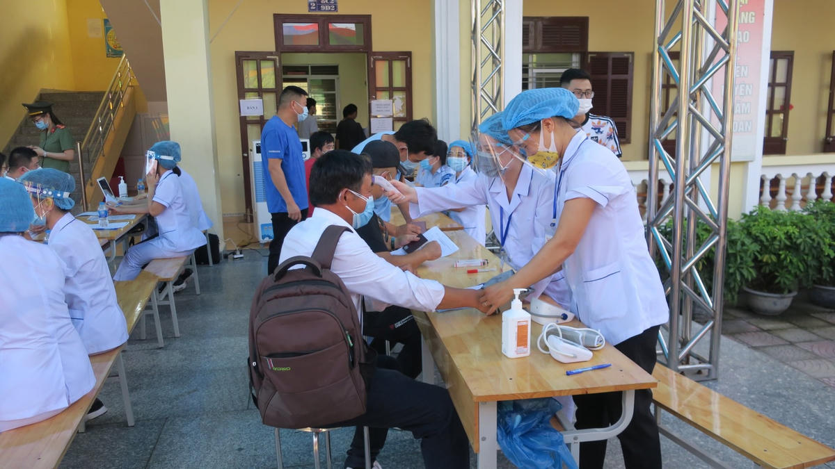 Các nhân viên y tế thực hiện khám sàng lọc sức khỏe cho người dân trước khi tiêm Vaccine.