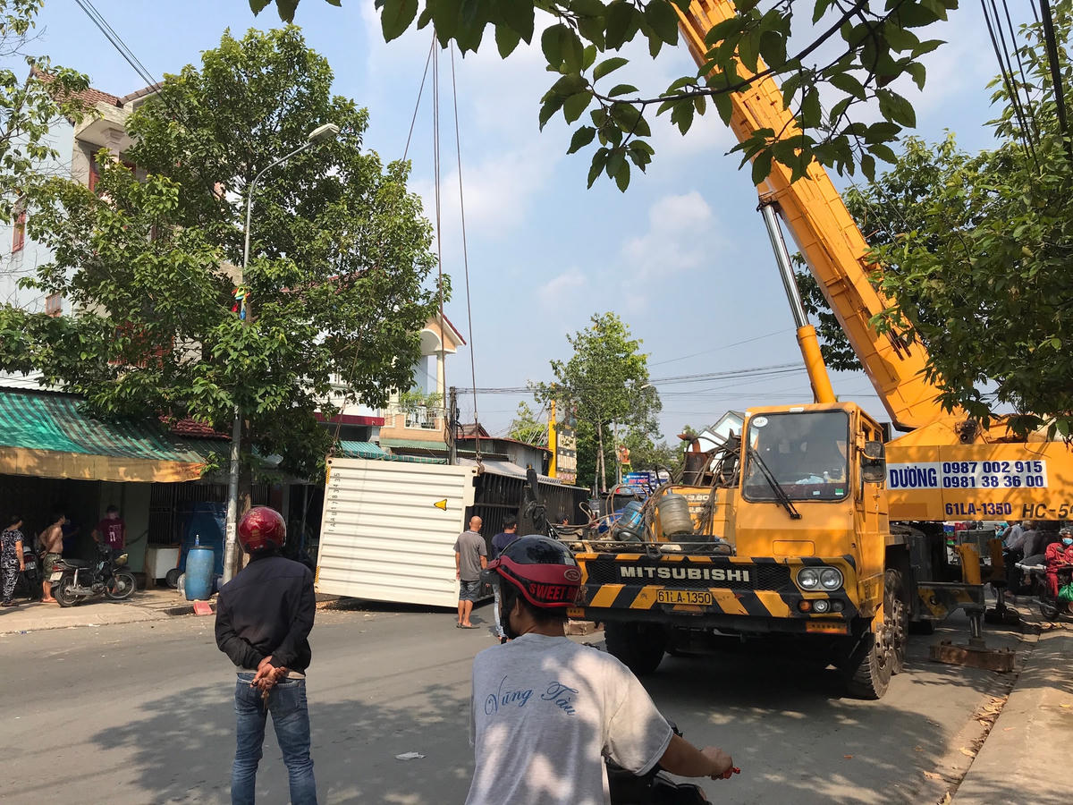 Lực lượng chức năng điều xe cẩu đến cẩu thùng container khỏi hiện trường. Ảnh: Trung Lĩnh.