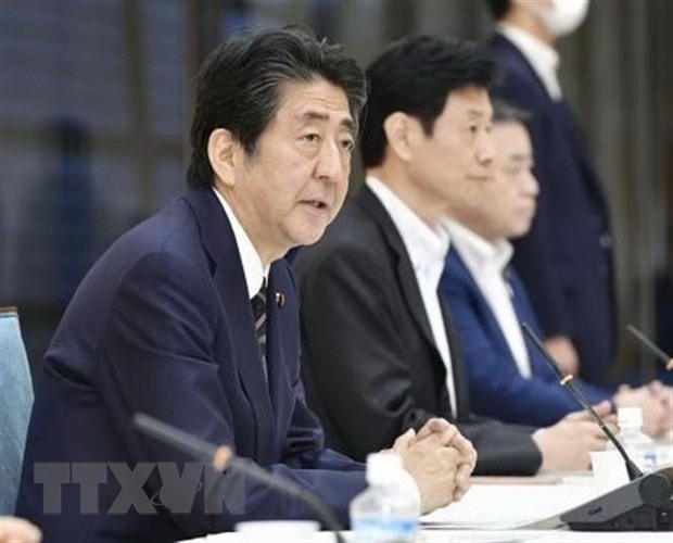 Thủ tướng Nhật Bản Shinzo Abe (trái) tại cuộc họp nội các ở Tokyo, Nhật Bản, ngày 30/7/2020. (Ảnh: Kyodo/TTXVN).  