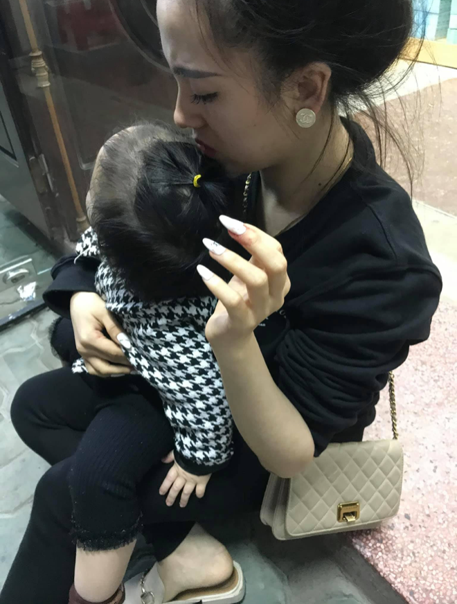 Người vợ bế con nhỏ sau khi xảy ra vụ việc. Nguồn: Hoàng Vũ.