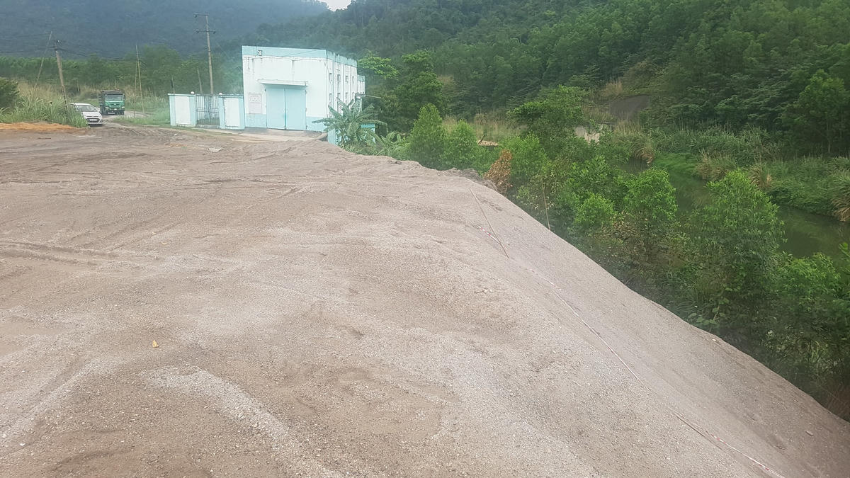 Tro xỉ từ Công ty Nhiệt điện Sơn Động đổ thải trái quy định ra môi trường, ngay sát nguồn nước. Ảnh: Hà An.