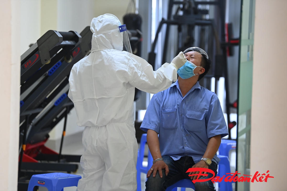 Lực lượng y tế lấy mẫu xét nghiệm cho những người liên quan tại khu chung cư. Ảnh: Quang Vinh. 
