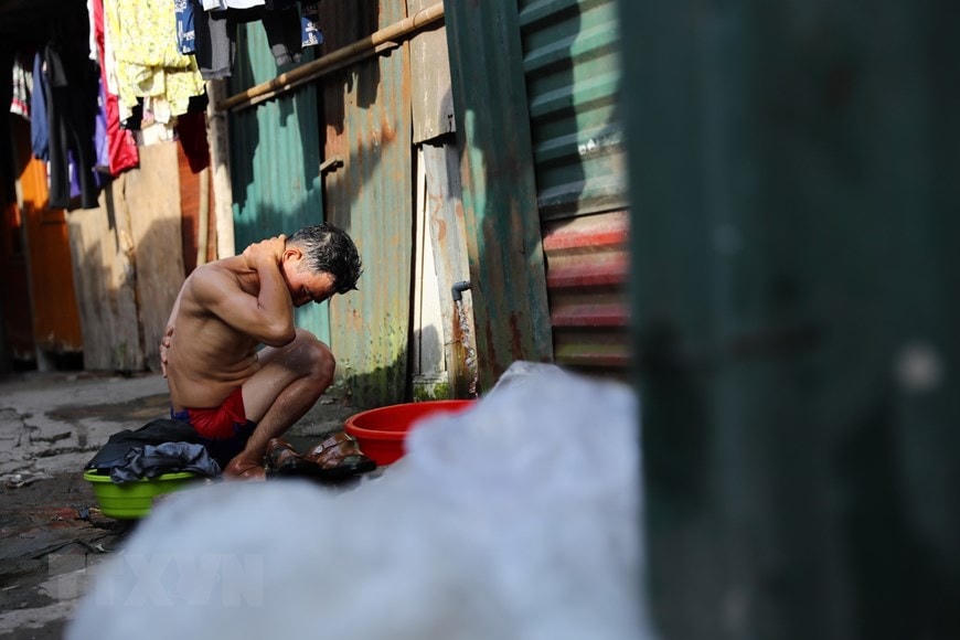 Cuộc sống thường ngày của người lao động xóm trọ Phúc Xá dưới cái nóng gay gắt, oi nồng. (Ảnh: Thành Đạt/TTXVN).